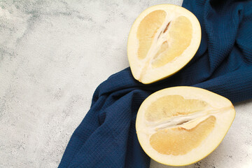 Close up ripe juicy fresh cut sliced yellow Pomelo on cement grey color cement background with blue...