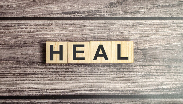 heal words on wooden blocks and brown background