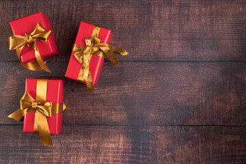 Brown wooden background with three gift boxes