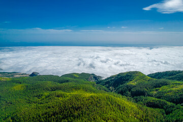 Wide mountain panorama with white puffy clouds below in Tenerife island, Spain