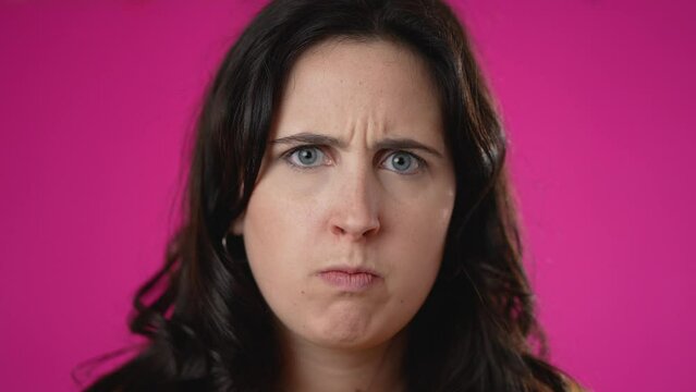 Slow motion pretty brunette young woman 20s 30s did not get enough sleep last night after party and barely got up in the morning yawning. Closeup portrait isolated on pink background in studio.