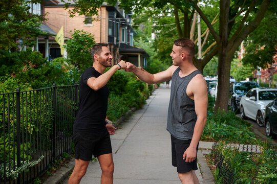 Men bumping fists after exercising.