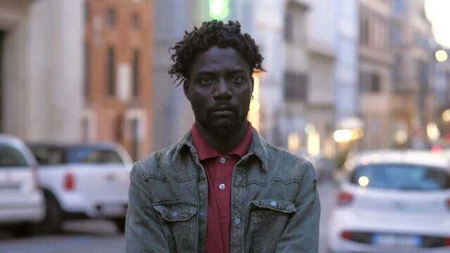 angry serious young black man in the street staring seriously at camera
