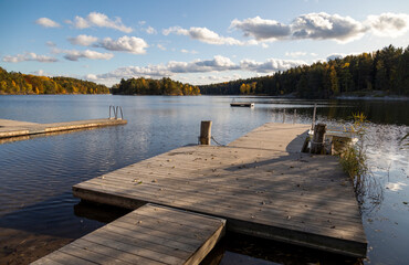 Wooden boat jetty on the lake in autumn day