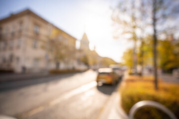 Autumn season bokeh background. Abstract city blur along the road with cars.