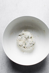 Dry noodles dough, homemade herbed noodles, process of making noodles, dough in white bowl	