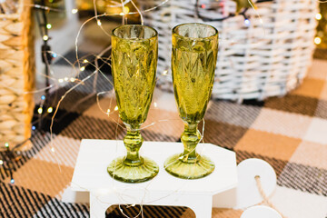 Glasses of sparkling champagne near the Christmas tree, garland and Christmas decoration. Christmas and New Year celebrations.