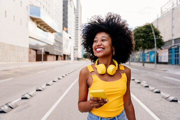 Beautiful young black woman outdoors in the city - Afro american cheerful female adult portrait