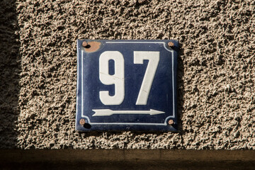 Weathered grunge square metal enameled plate of number of street address with number 97