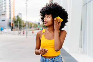 Beautiful young black woman outdoors in the city - Afro american cheerful female adult portrait