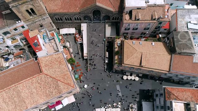 Aerial view of Amalfi Coast, Italy. Drone view of Cathedral of Saint Andrew, embankment, red roofs of buildings in old town, historical and tourist places, and cruise ship