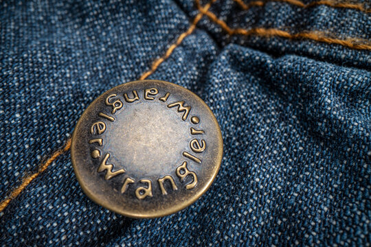 Fort Collins, CO, USA - November 14, 2022: Closeup of Wrangler metal button on a trucker denim jacket. Wrangler is American manufacturer of jeans and other clothing.