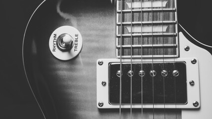 Electric guitar on a black background. Black and white photo.