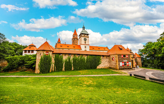 Bouzov castle. Fairytale castle in czech highland landscape. Castle with white church, high towers, red roofs, stone walls. Czech republic.