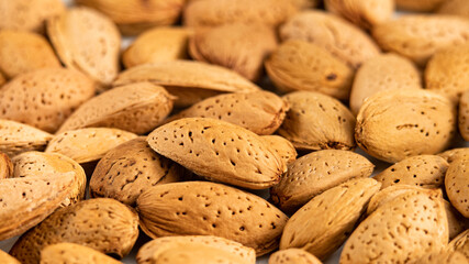Raw Almonds Nut in Shells as Food Background. Organic Almond for Vegans. Side View, Healthy Food. Products with Healthy Fats. Shelled Almonds with Selective focus