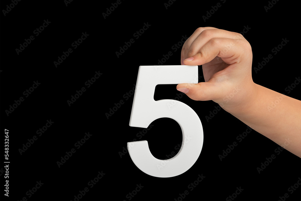 Poster Number five in hand isolated on black background. Number five in the hand of a child holding on a black background. To be inserted into a project or design.