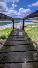 Fototapeta na wymiar Escadaria de madeira na lagoa Várzea das Flores em contagem, lindo céu azul e as águas da lagoa banhando a orla ao fundo.