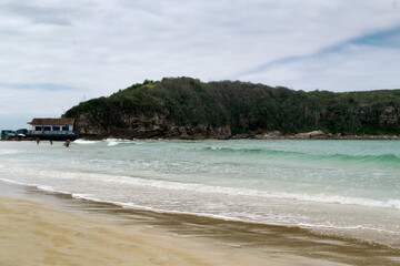 Linda praia das Conchas, próxima a cidade de Cabo Frio, com mar azul em volta, céu com nuvens e...