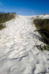 Orla da Praia das Dunas, com algumas dunas de areia, e subida arenosa para chegar a praia.
