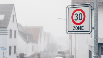 Zone 30. Schild mit der Nebligen Innerorts Straße im Hintergrund © Anselm