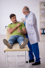 Fototapeta premium Young male patient visiting old male doctor in vaccination conce