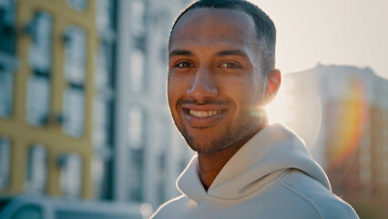 Close up male portrait in morning sun rays young athletic handsome afro american latino guy stand...