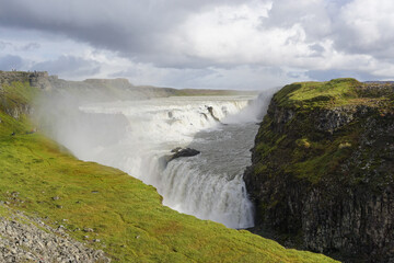 Southwest Iceland: Mist rising from Gullfoss (Golden Falls), the most famous waterfall in Iceland. Water from the Langjokull glacier flows into the Hvita (White) River.