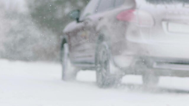 Slow motion, low angle, close-up. Rotation of a car wheel on a snowy road