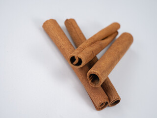 A bunch of cinnamon sticks on a white background. Cinnamon sticks are a very fragrant brown spice. Close-up and there is room for insertion.