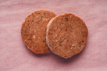 two servings of frozen red meat patties, preparation for burgers