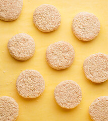 Frozen turkeys meat cutlets in breading on a yellow background for frying