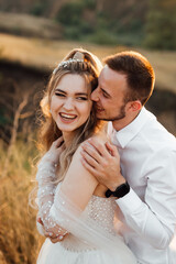 a cheerful couple in love, the bride and groom cheerfully and laughing meet the sunset