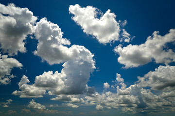 White puffy cumulus clouds on summer blue sky