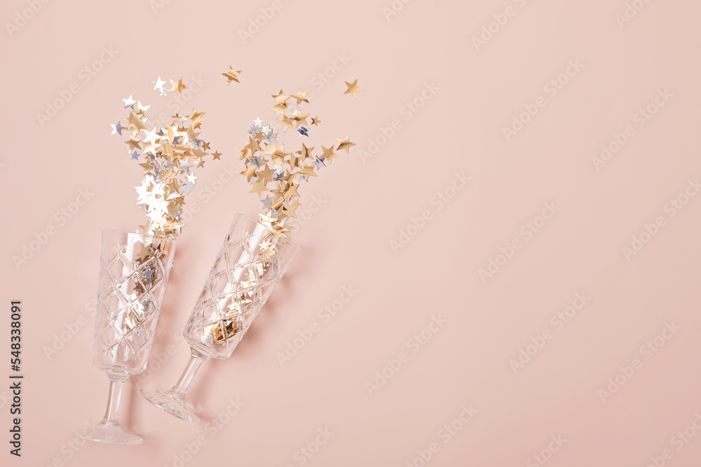 Wall mural Champagne or sparkling wine glasses with confetti over pink background. Christmas, new year party, birthday or wedding celebration idea. Top view, flat lay, copy space