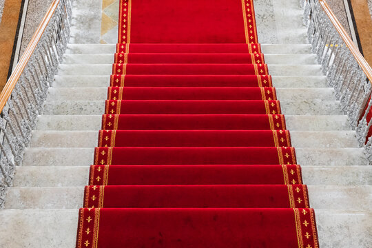 Red carpet is at a white stone stairway, top view, background