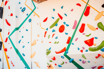 Wall with climbing holds in gym. Practicing rock-climbing on a rock wall outdoor. Xtreme sports and...