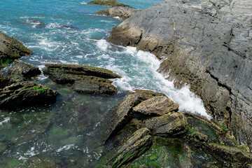 Praia no Forte São Mateus, com grande rochas onde a água do mar passando entre elas, formando...