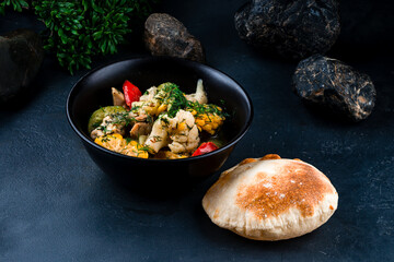 Lunch chicken stew with cauliflower, corn, zucchini, bell peppers, onions, herbs and tortilla.