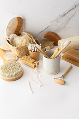 Wooden toothbrushes with natural bristles in a ceramic glass, face and skin care products, bath accessories, spa and beauty concept