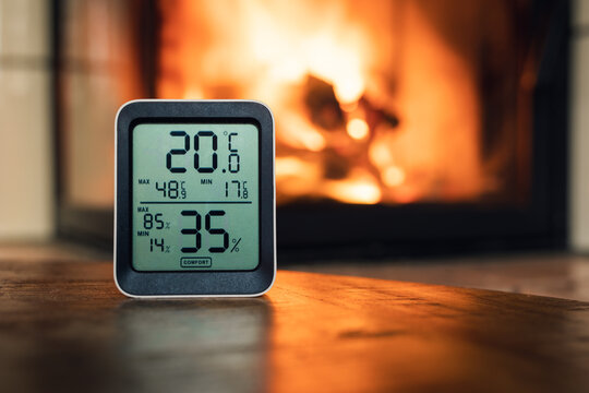 Thermometer in front of fireplace which shows temperature and humidity.