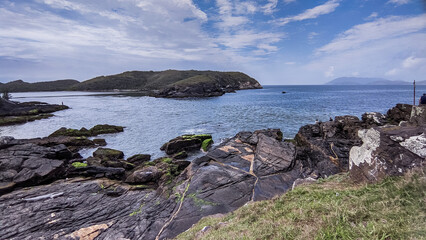 Vista de cima do forte da Praia do Forte, grandes rochas, céu azul com nuvens e um lindo mar em volta.