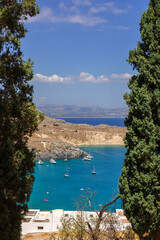 Panoramic view of colorful harbor in Lindos village, Rhodes. Aerial view of beautiful landscape, sea with sailboats and coastline of island of Rhodes in Aegean Sea. High quality photo