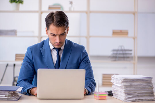 Young male employee and too much work in the office