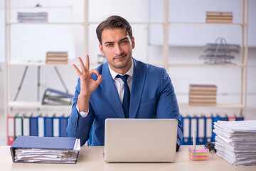 Naklejka premium Young male employee and too much work in the office