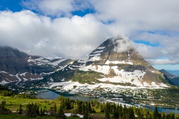 Scenery with flowing water surrounded by vegetation and snowy mountains