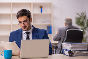 Old male boss and young male employee in the office