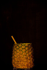 Exotic pineapple in the shape of a drink, with organic straw and mini umbrella