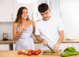 Young happy married couple cooks breakfast in the kitchen in the morning