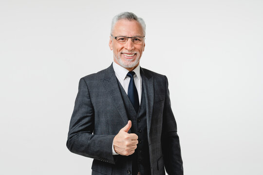 Rich mature middle-aged elderly businessman boss ceo caucasian millionaire professor in formal attire showing thumb up, approval isolated in white background