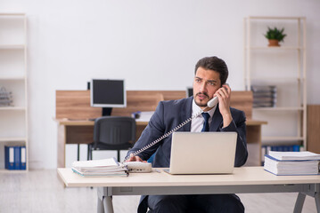 Young male employee sitting at workplace